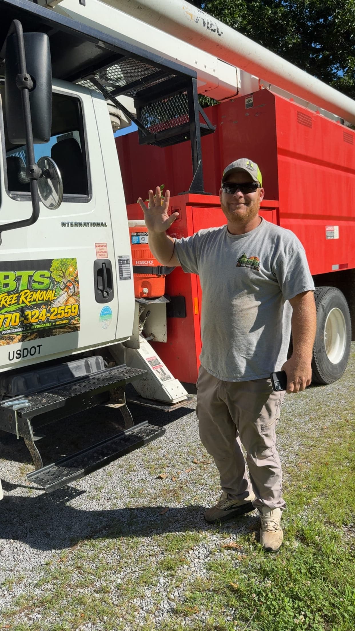 Friendly BTS Tree Removal crew member by the company bucket truck